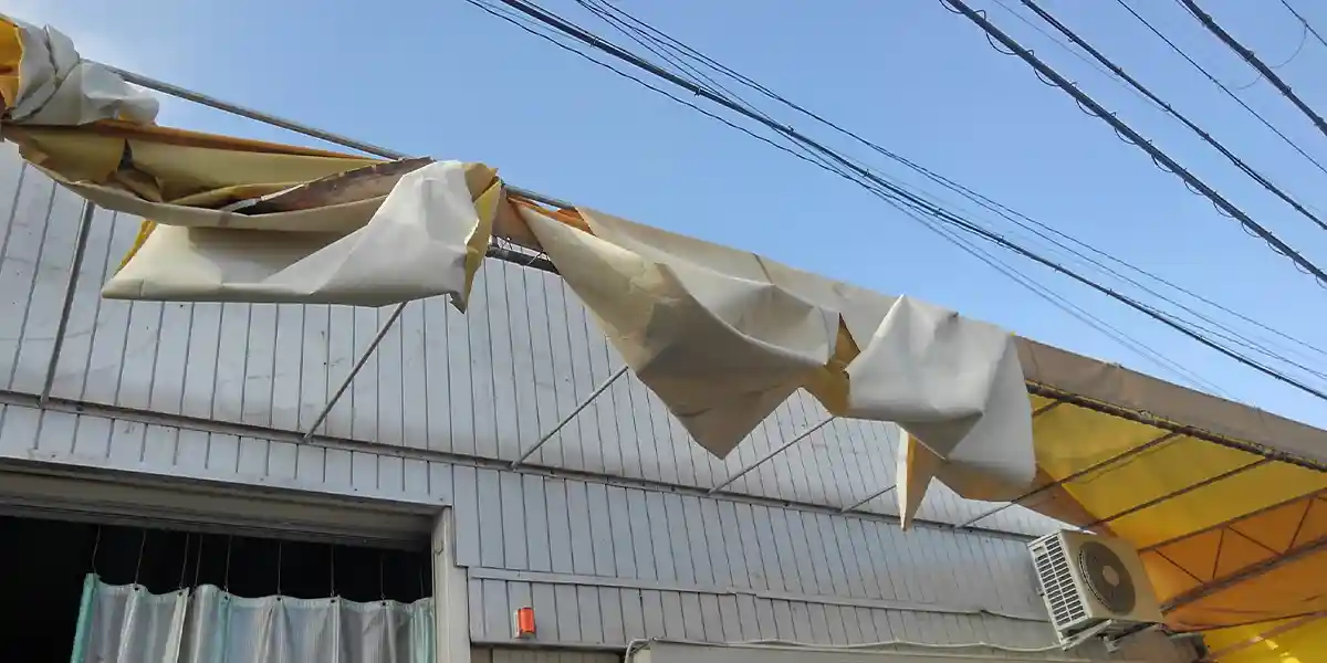 台風等の災害による看板修理：台風被害で敗れたテント