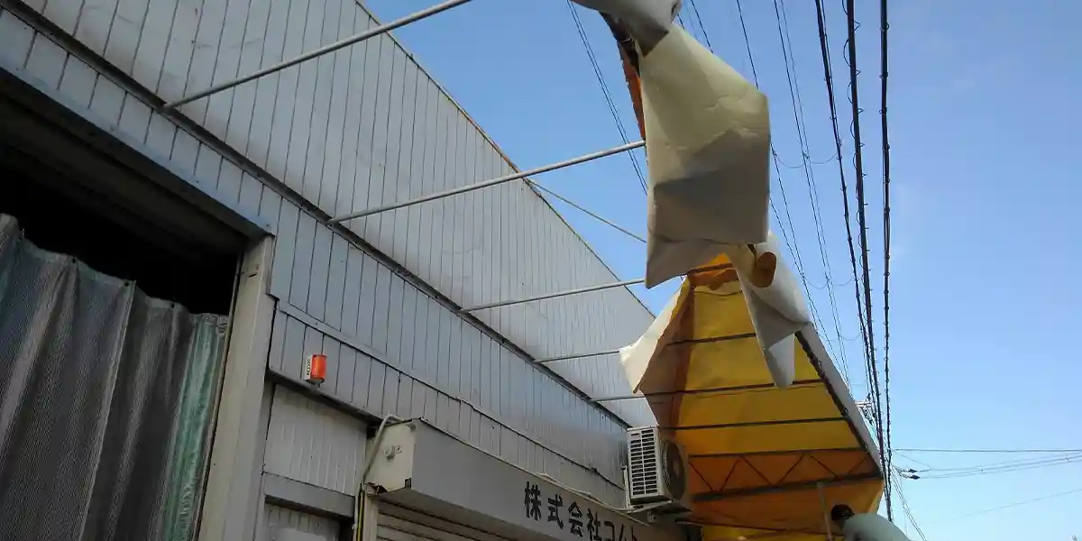 台風等の災害による看板修理：台風被害で敗れたテントの現場調査